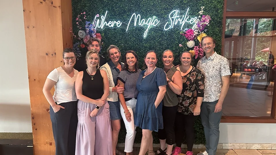 The Montgomery Wolken Dental Care team together in front of a flower wall.